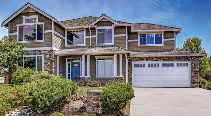 A large house with a white garage door and a lot of windows.