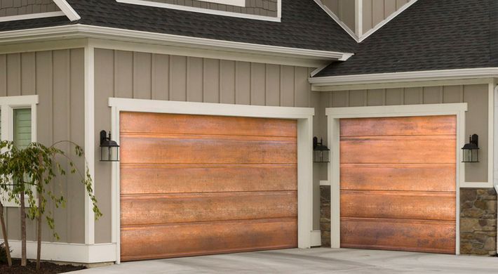 A house with two garage doors made of copper.
