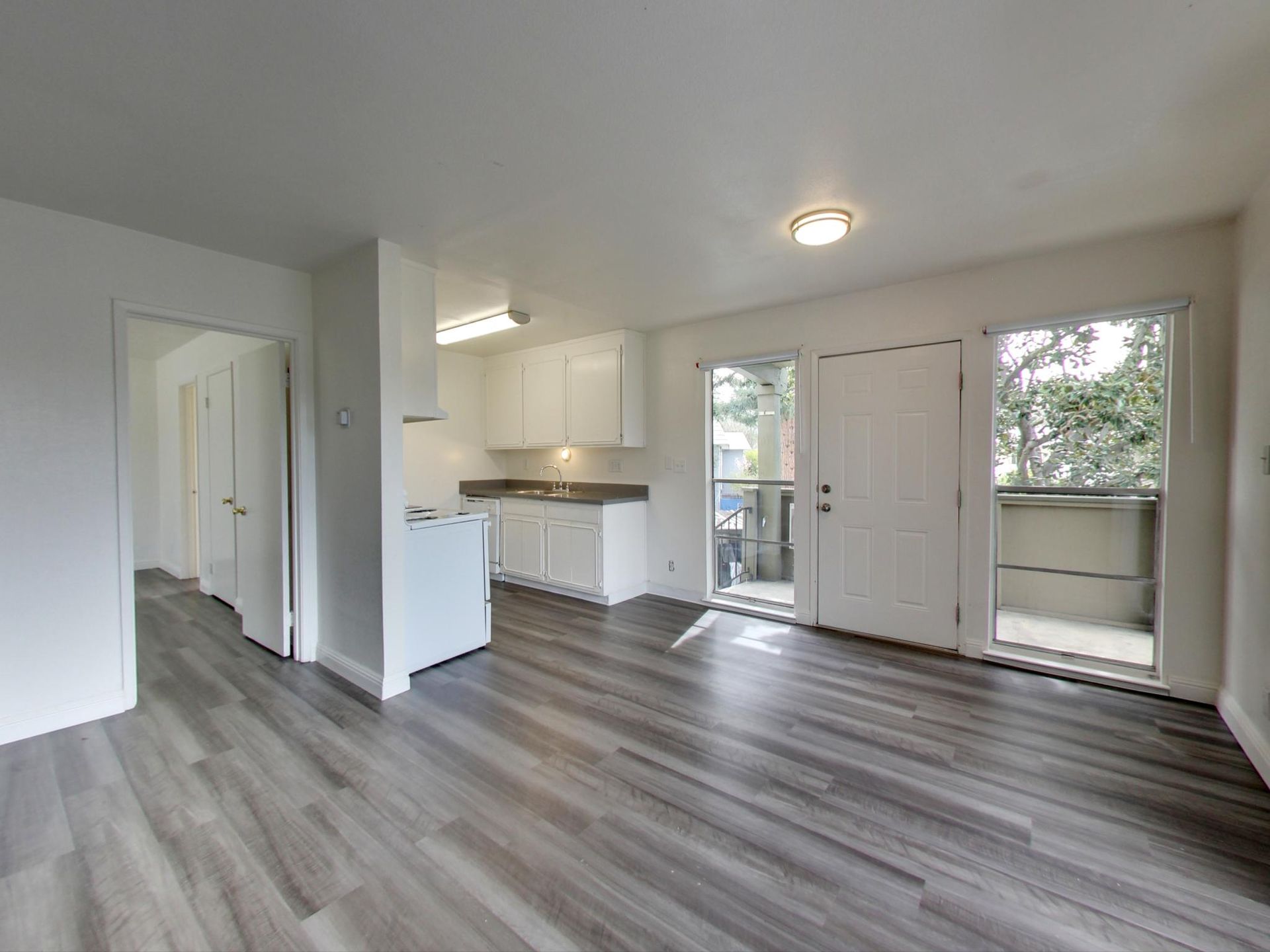 modern living room with a sofa, coffee table, bench, chair, tv and onlooking to a patio