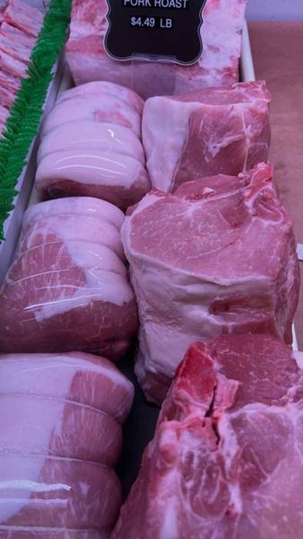 Pork roasts on display in a butcher shop, priced at $4.48/lb.