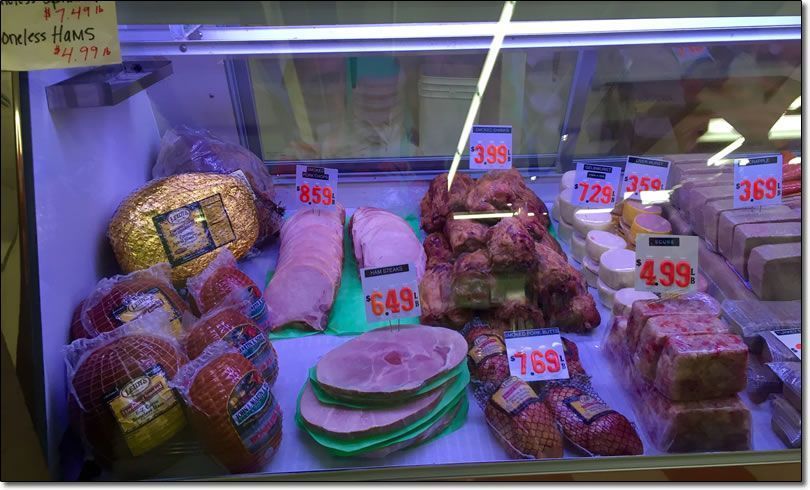 Meat display case with various packaged meats, prices visible. Meat display case with various packaged meats, prices visible.