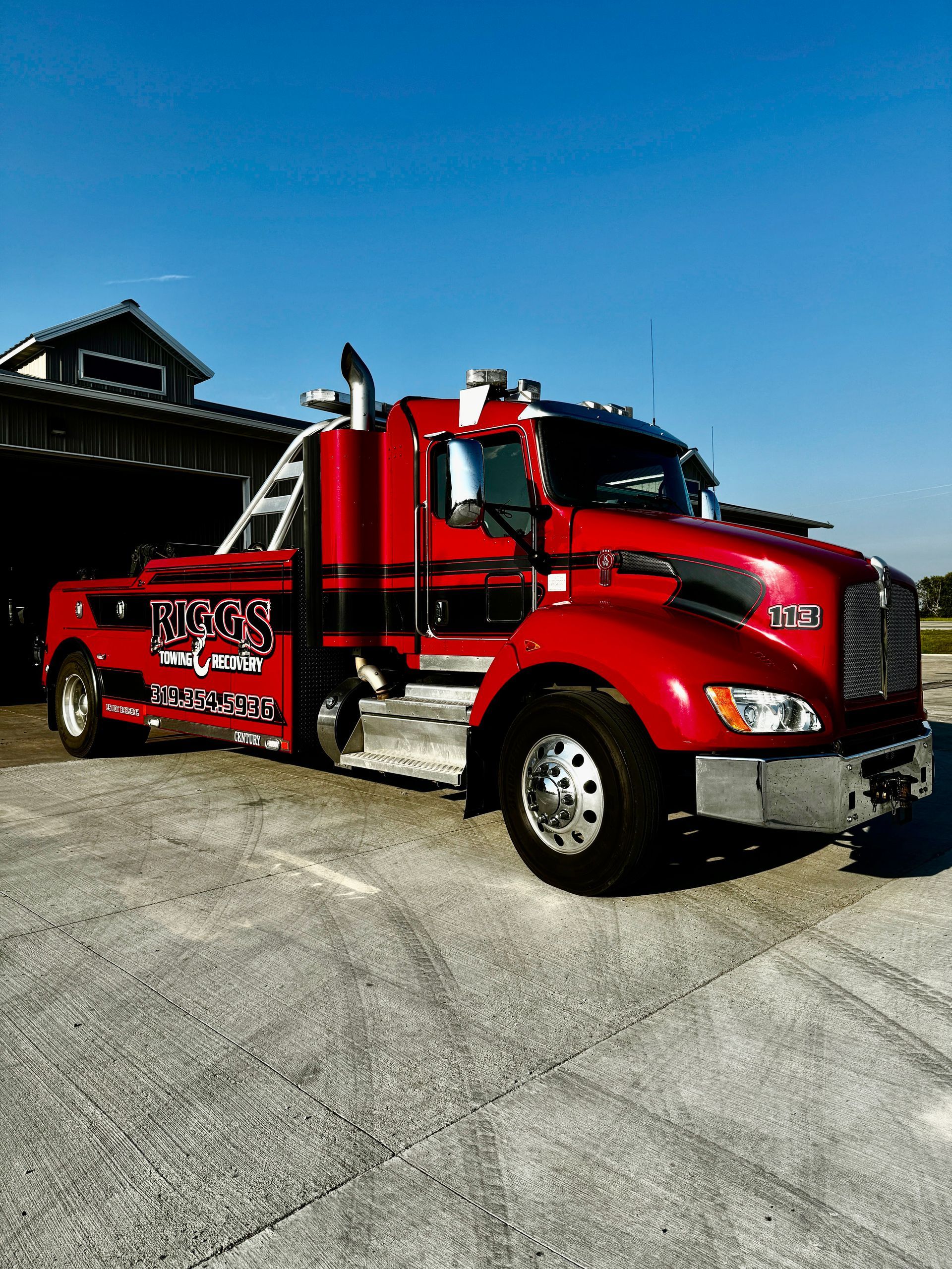 A red tow truck is parked in front of a building.