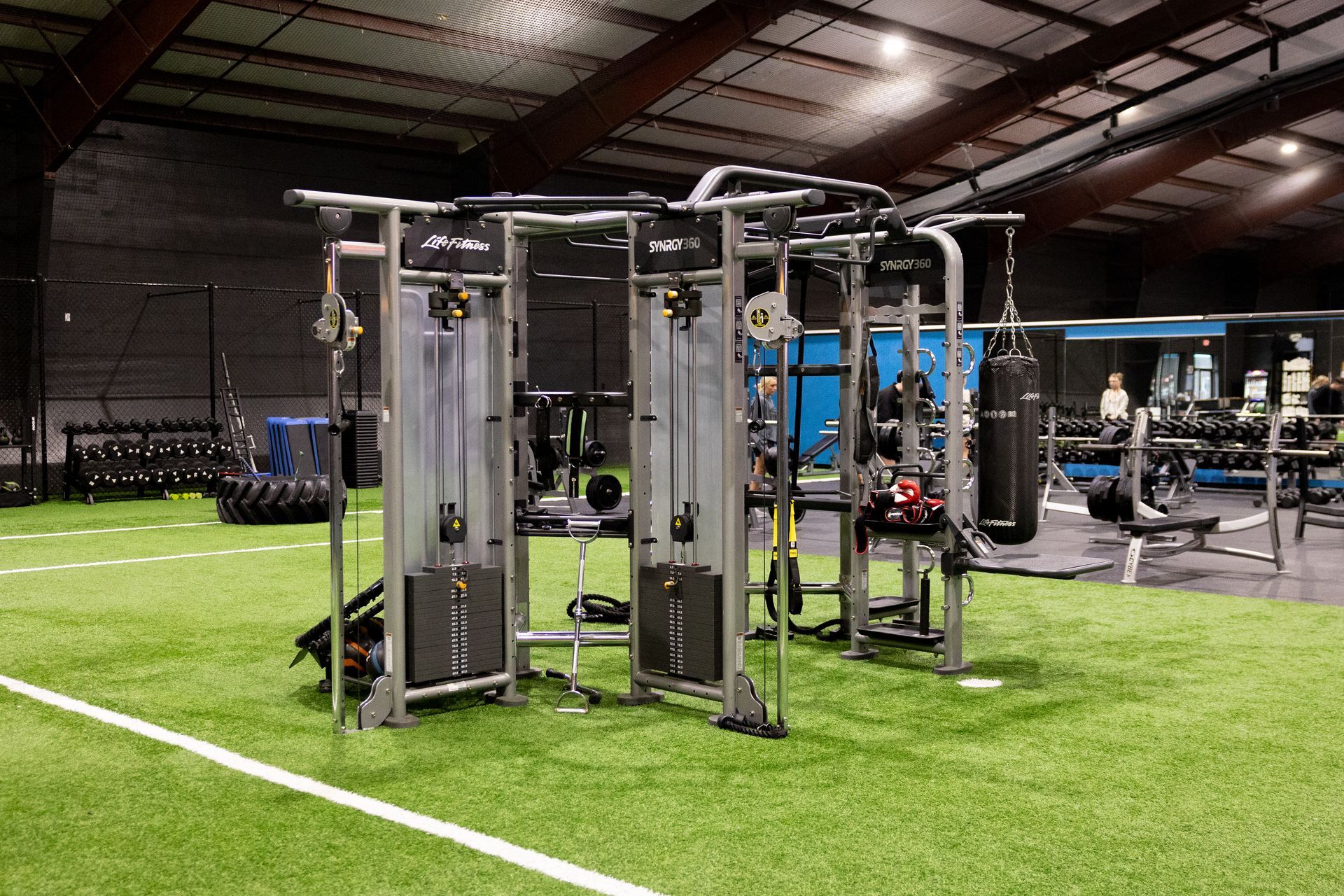 Wide view of the Freedom Fitness gym featuring cardio equipment, weight machines, free weights, and turf space.