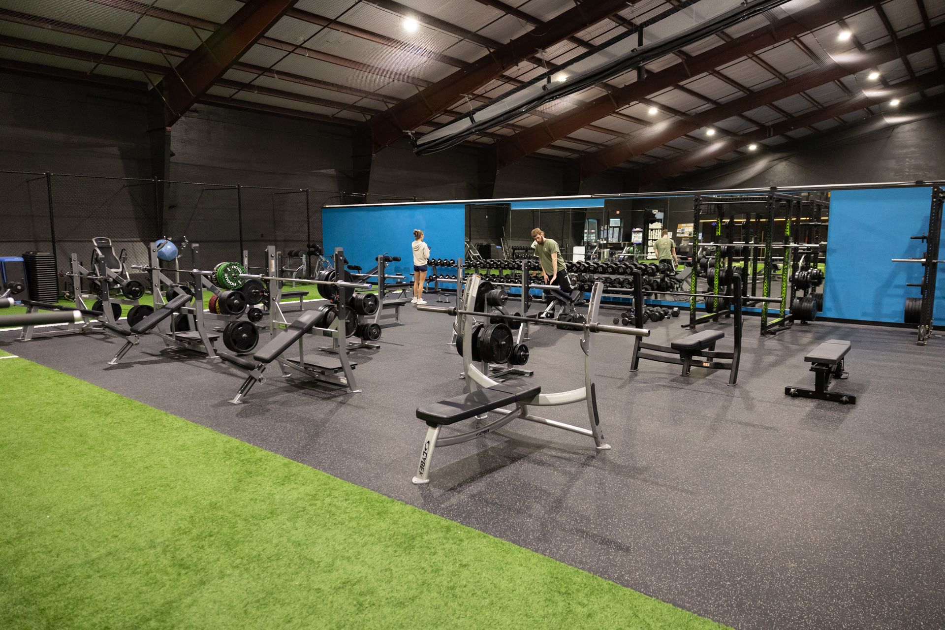 Wide view of the Freedom Fitness gym featuring cardio equipment, weight machines, free weights, and turf space.