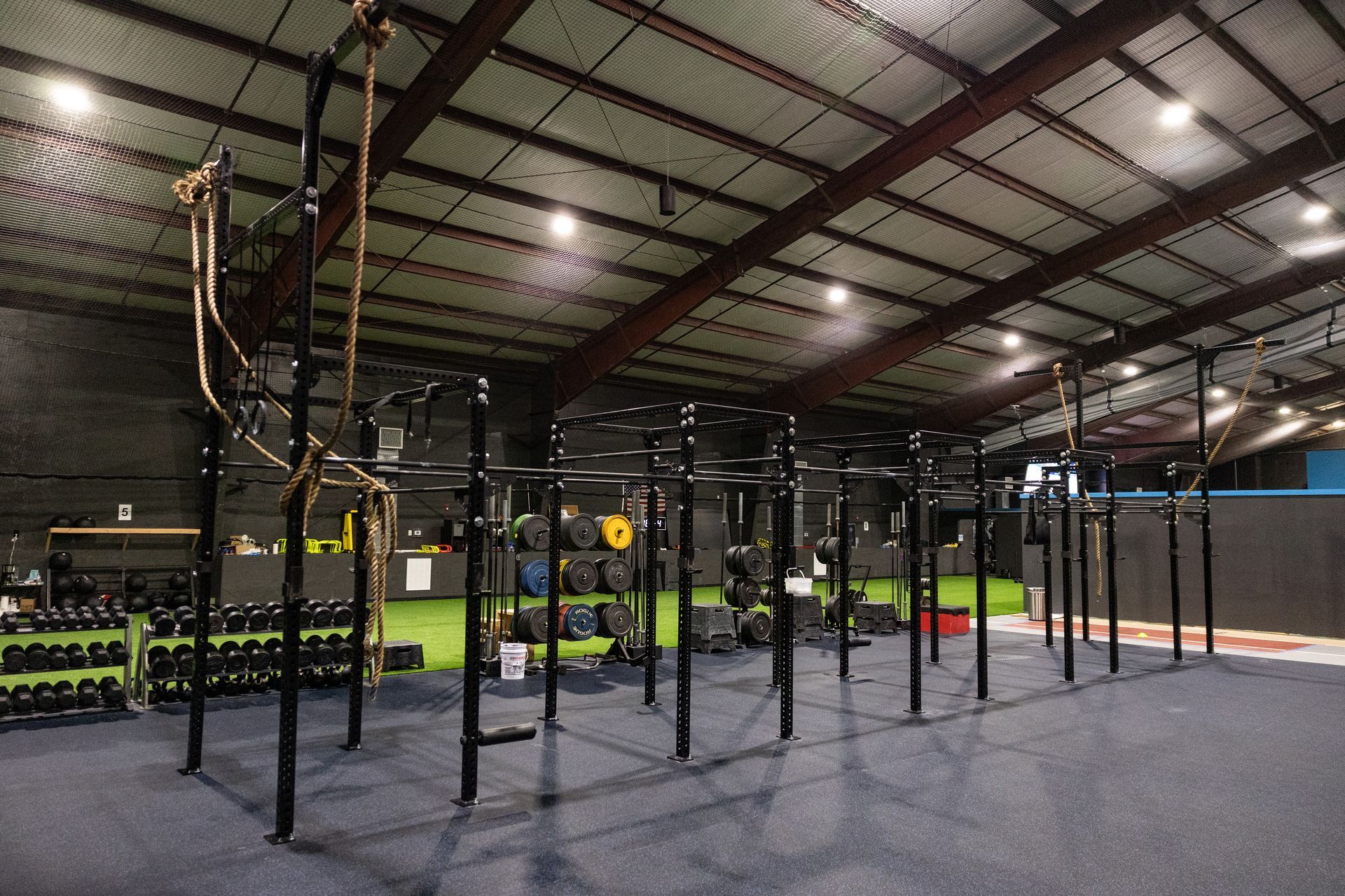 Wide view of the Freedom Fitness gym featuring cardio equipment, weight machines, free weights, and turf space.