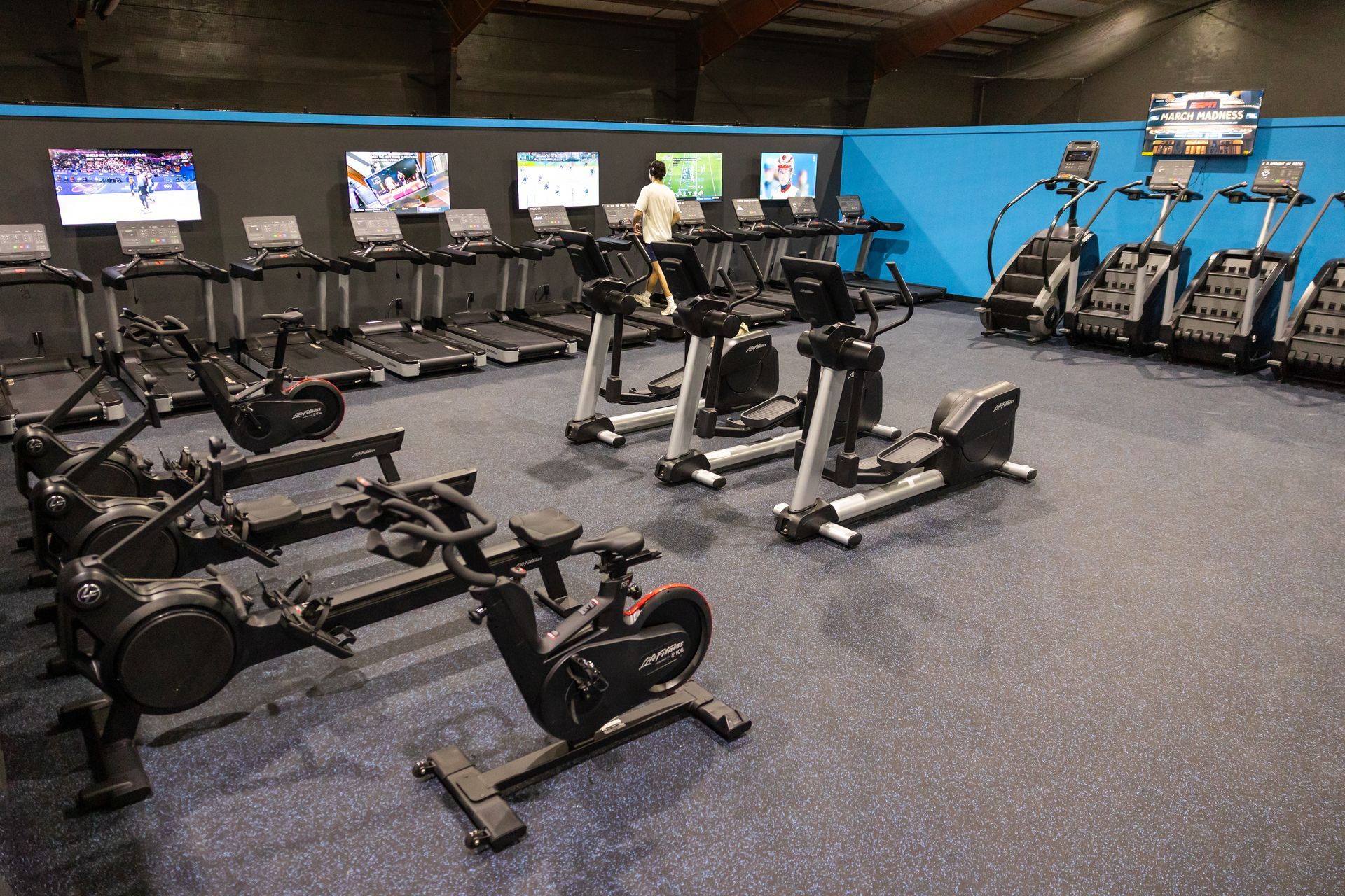 Wide view of the Freedom Fitness gym featuring cardio equipment, weight machines, free weights, and turf space.