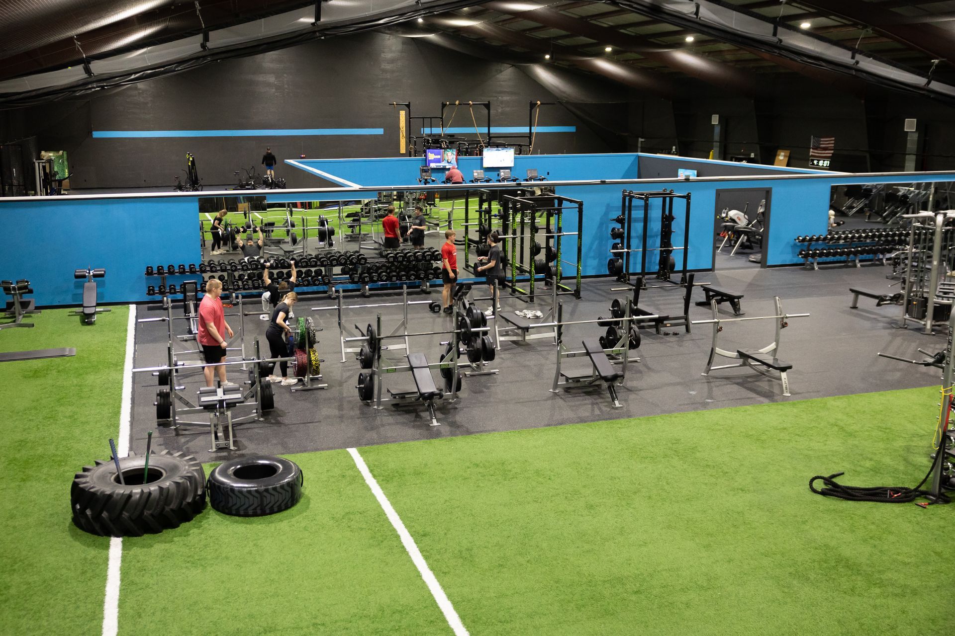 Wide view of the Freedom Fitness gym featuring cardio equipment, weight machines, free weights, and turf space.