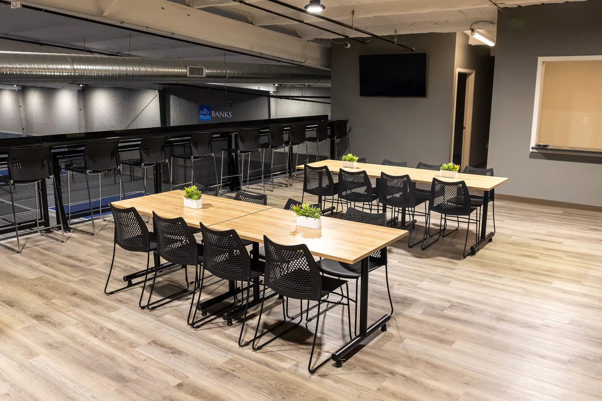Upstairs seating and lounge area at Freedom Fitness with tables, chairs, and a view overlooking the indoor pickleball courts.