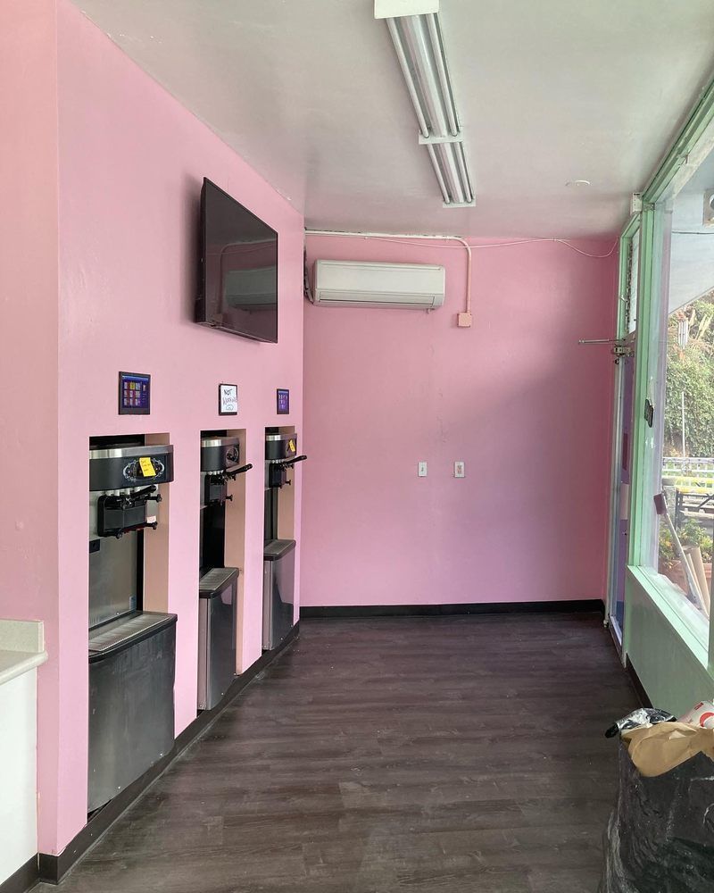 A room with pink walls and a tv on the wall
