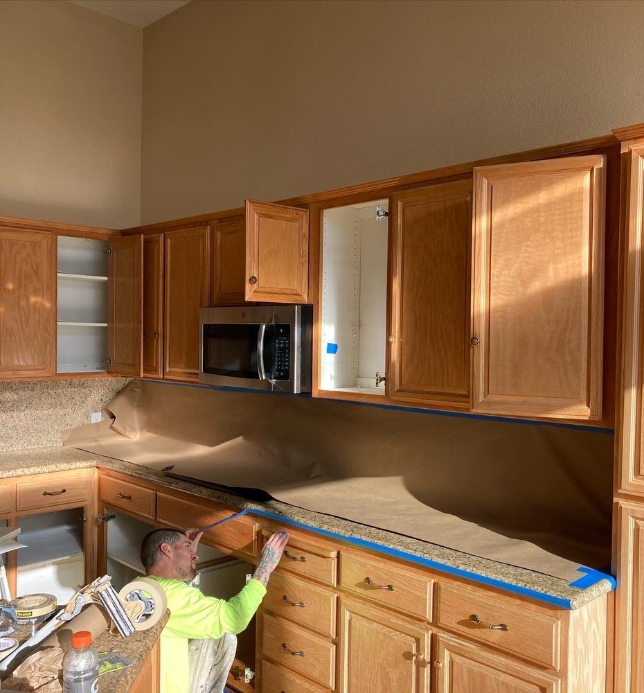 A man in a yellow shirt is working in a kitchen