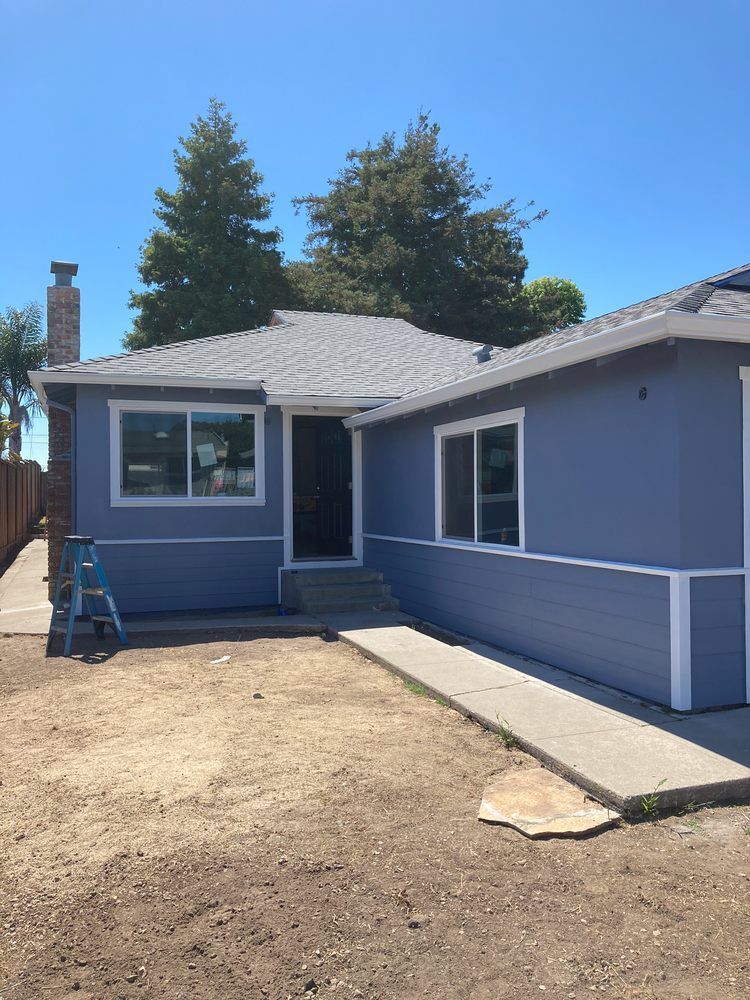 A blue house with a ladder in front of it