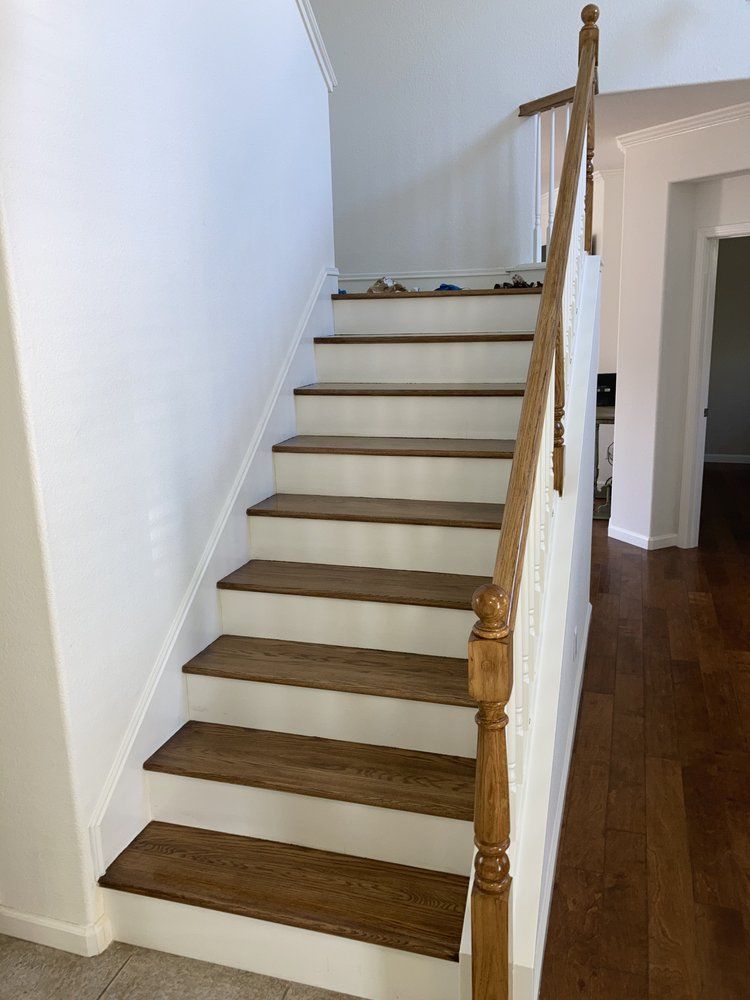 A staircase with wooden steps and a white railing in a house.