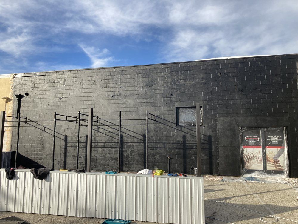 A black building with a white fence in front of it