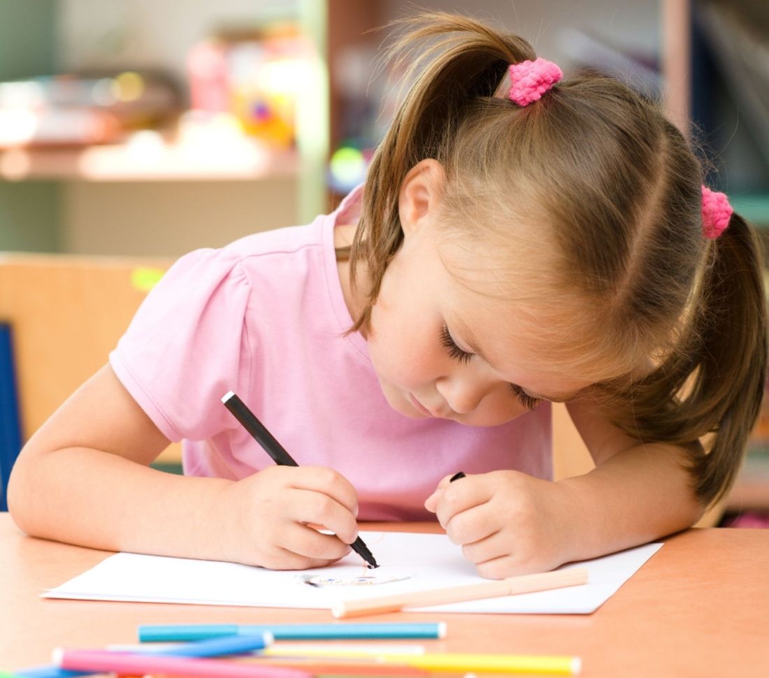 bambina disegna su un foglio