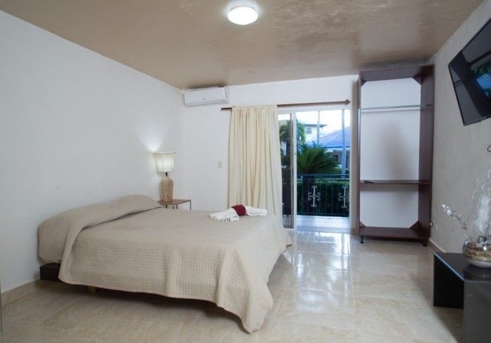 A bedroom with a large bed and a flat screen tv