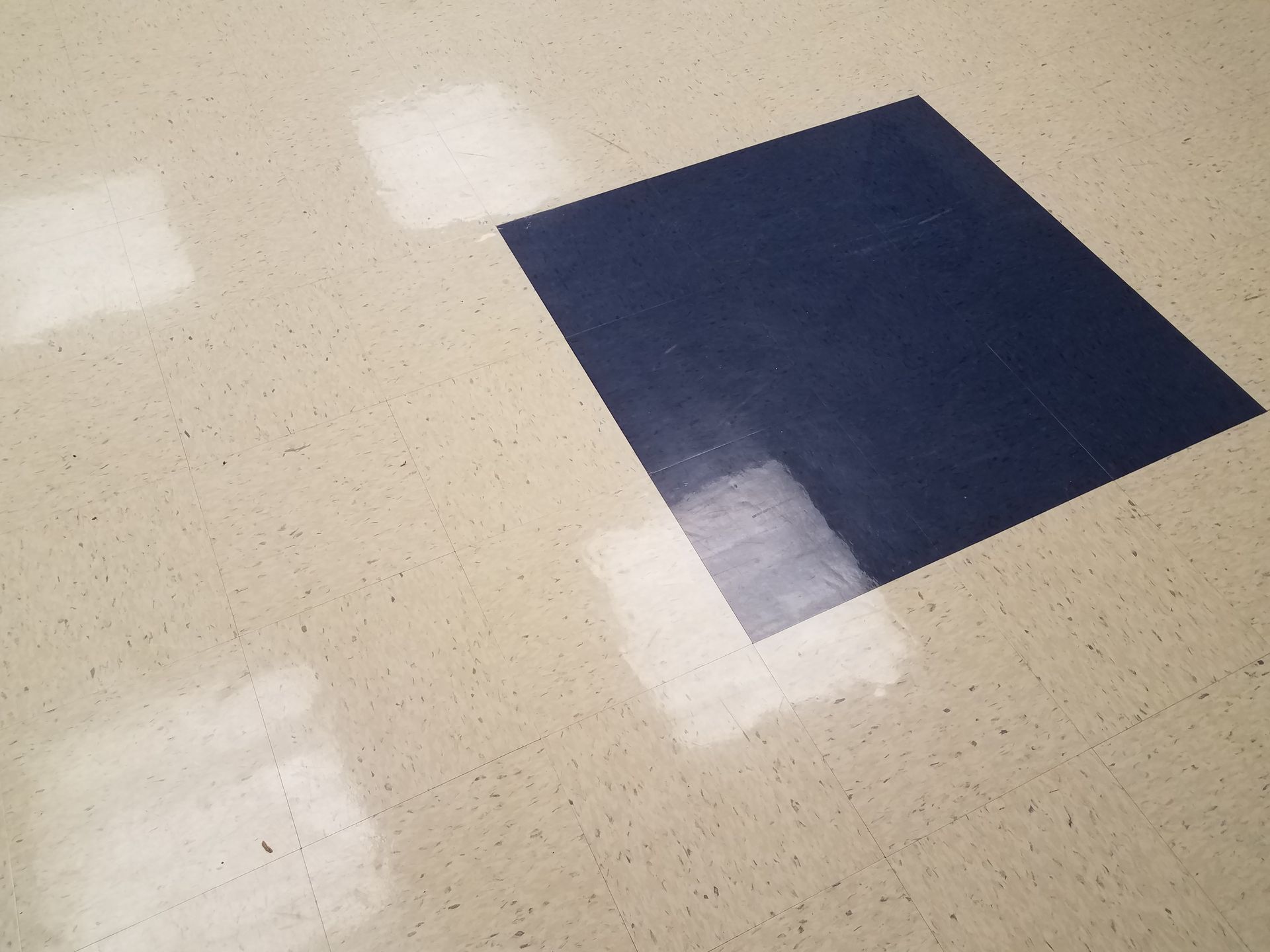 A white and blue VCT floor with a square in the middle