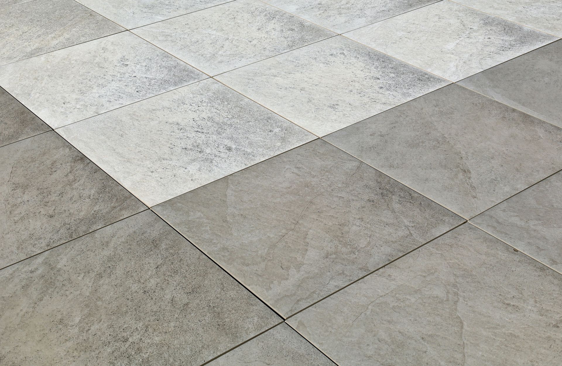 A close up of a gray and white tile floor.