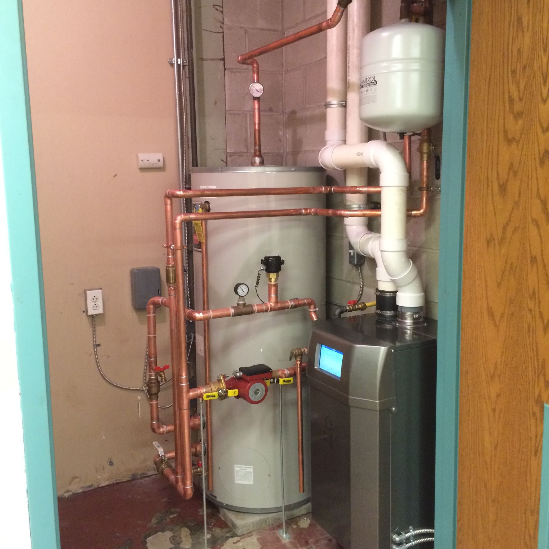Water heater and system with copper pipes in utility room.