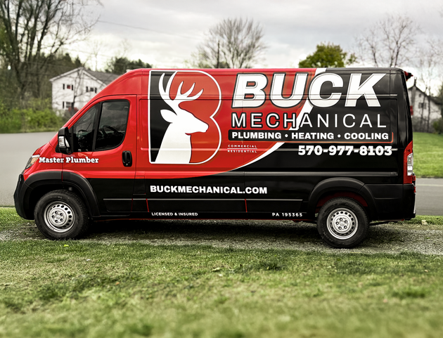 A gas water heater and copper piping installed in a small, indoor utility closet.