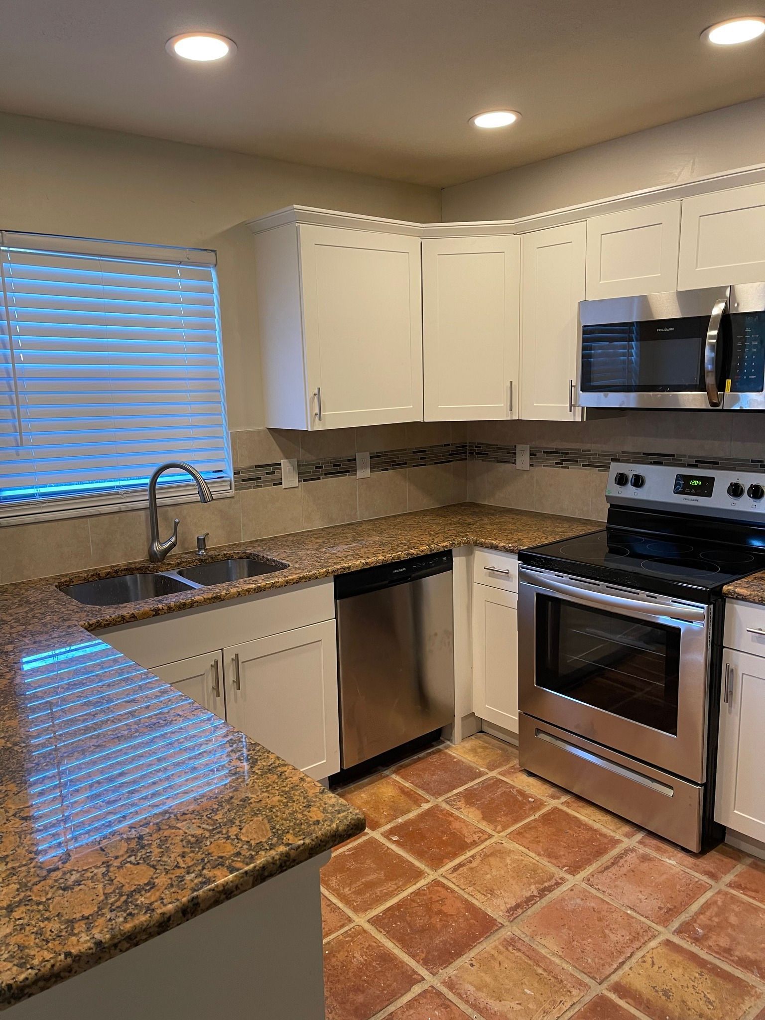 Kitchen with white cabinets, stainless steel appliances, and granite countertops.