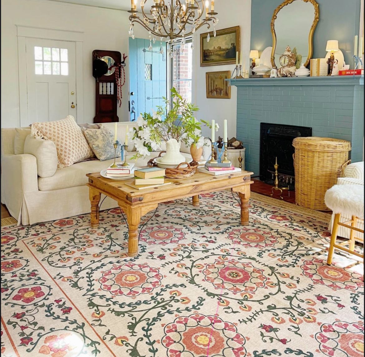 A living room with a floral rug and a fireplace