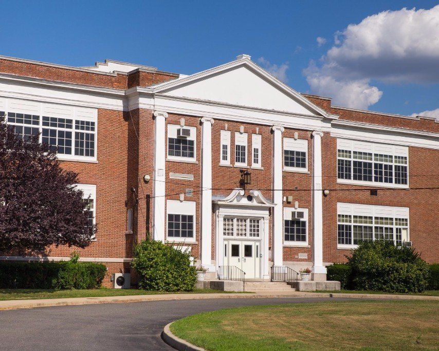 a large brick building with white trim and columns