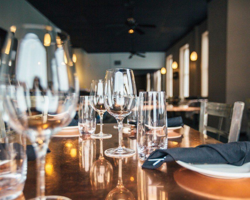 a row of wine glasses are sitting on a table in a restaurant .