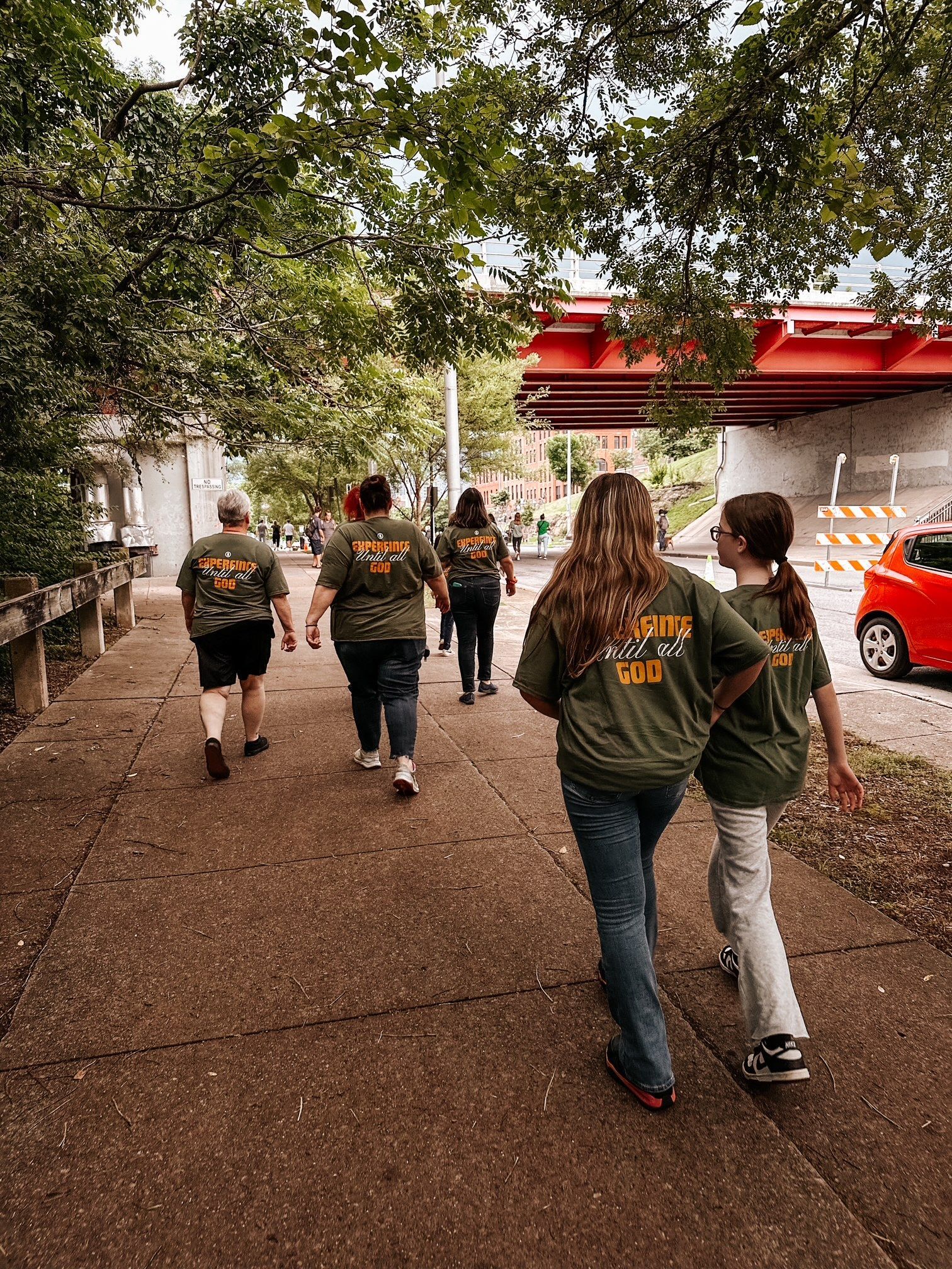 A group of people are walking down a sidewalk.