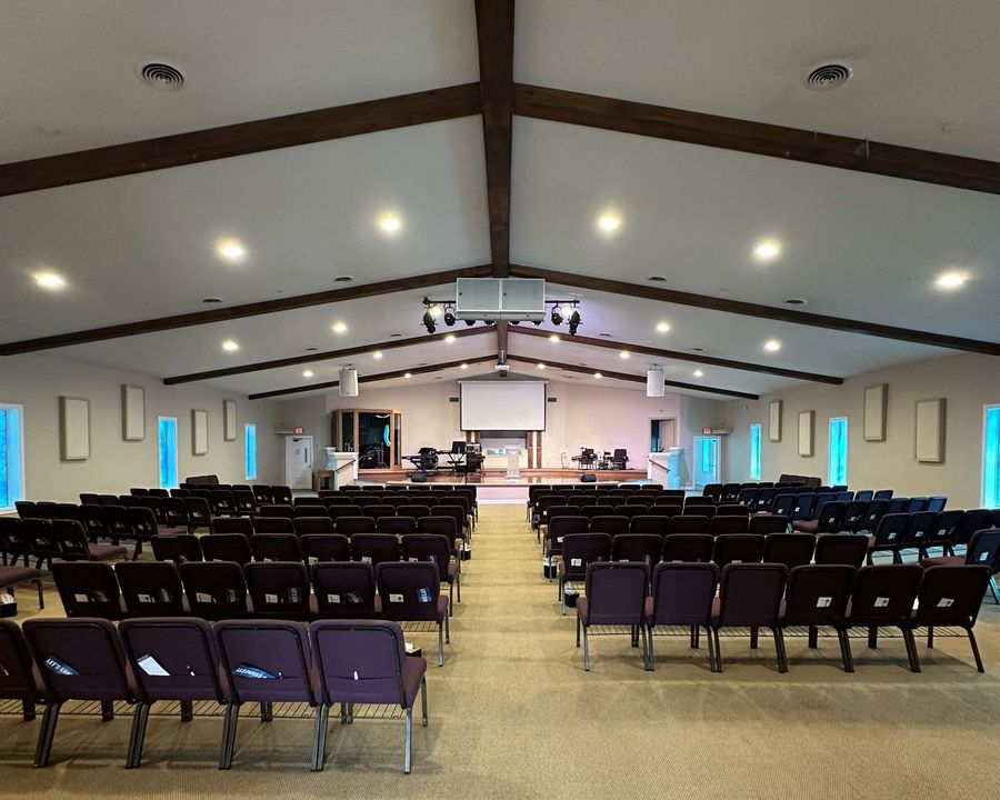 A large auditorium with rows of chairs and a projector screen.
