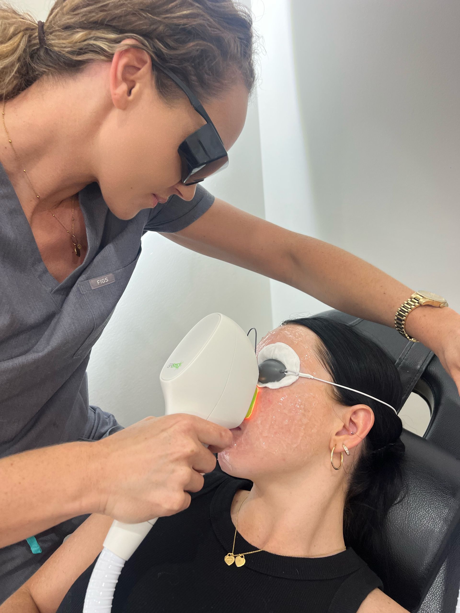 A Woman in a Black Shirt is Washing Another Woman's Hair — Nurose Aesthetics in Nundah, QLD