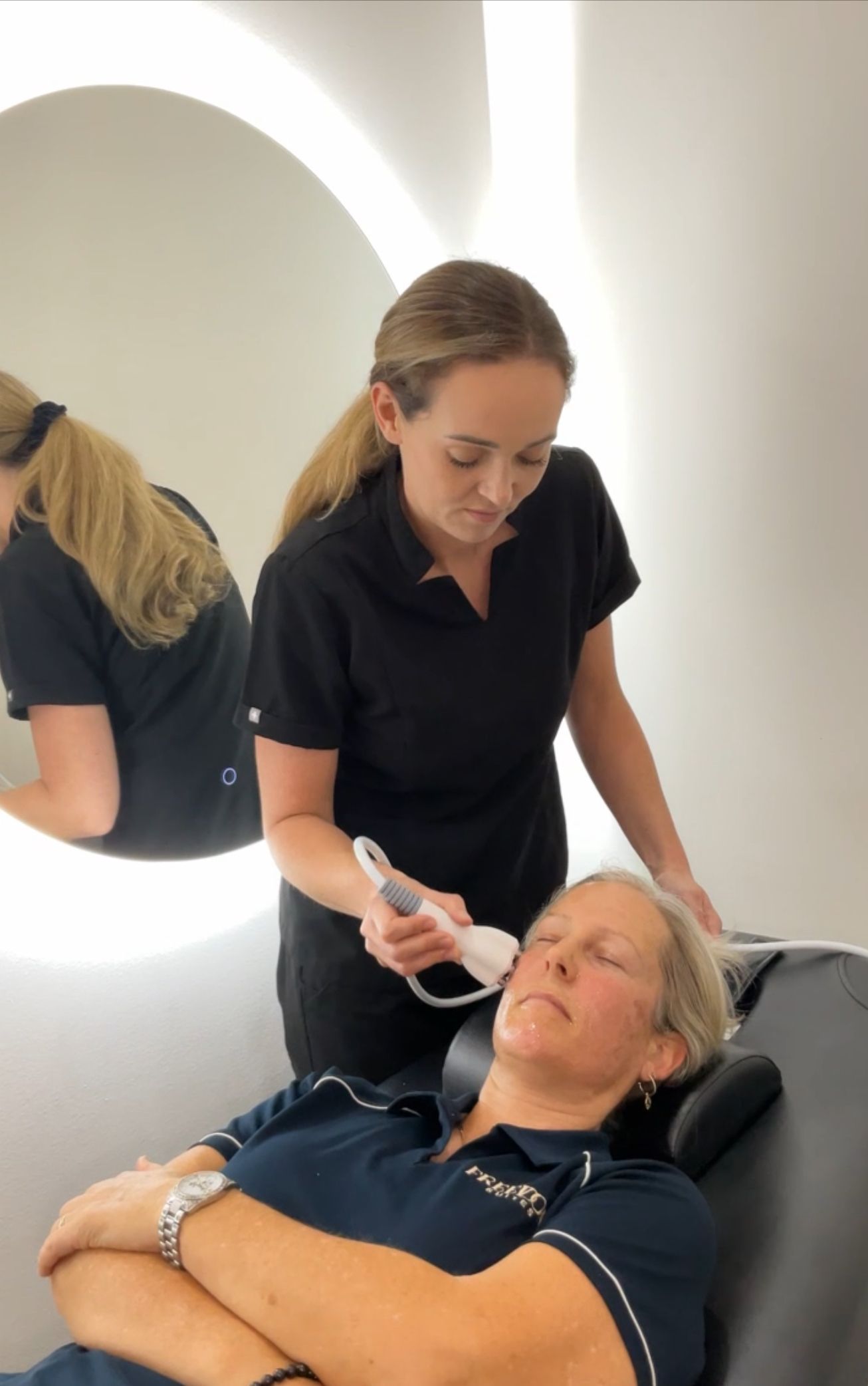 A Woman Wearing a Mask is Using a Machine on a Patient's Face — Nurose Aesthetics in Nundah, QLD