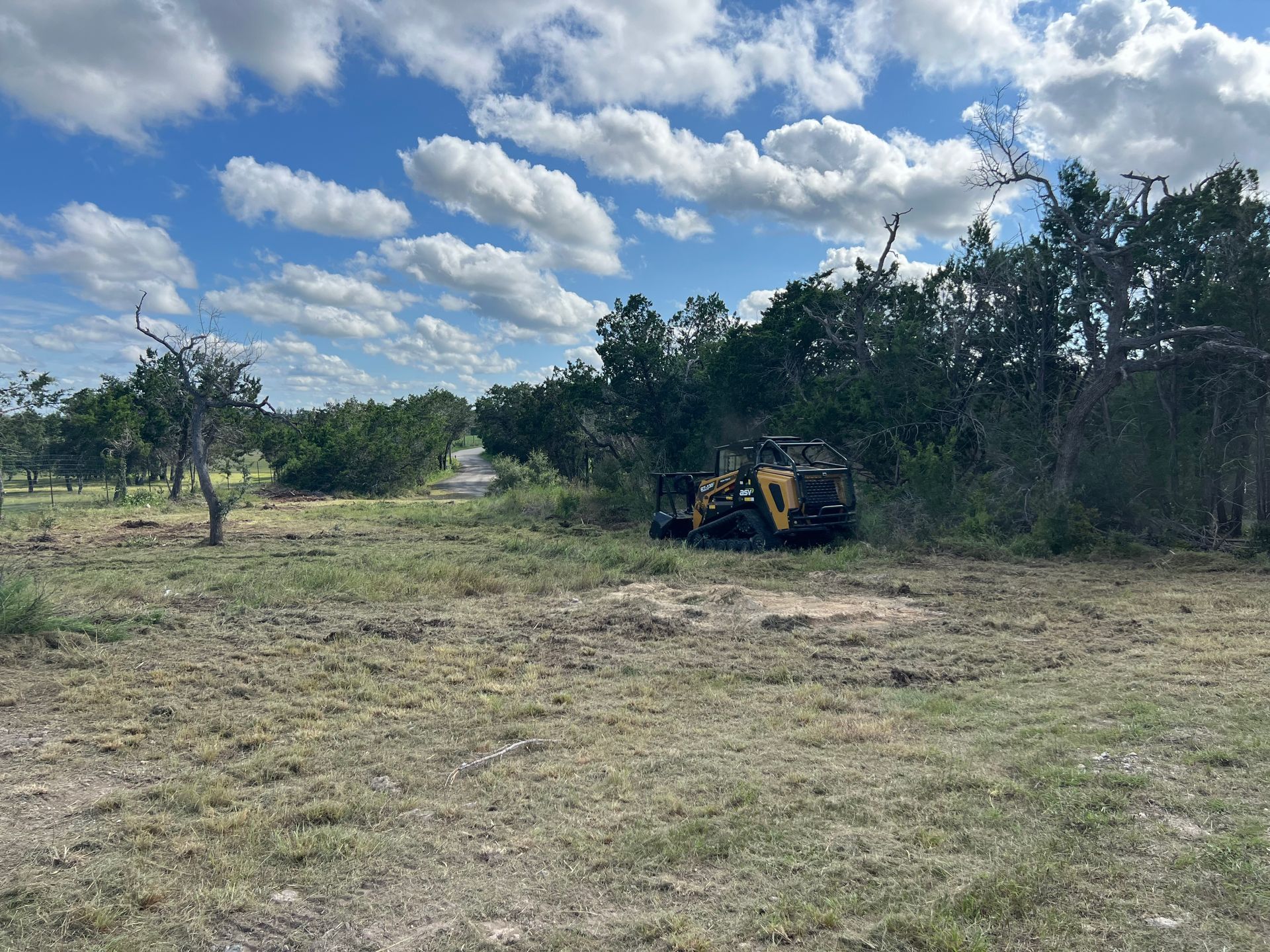 an excavator is digging a pile of dirt in a field