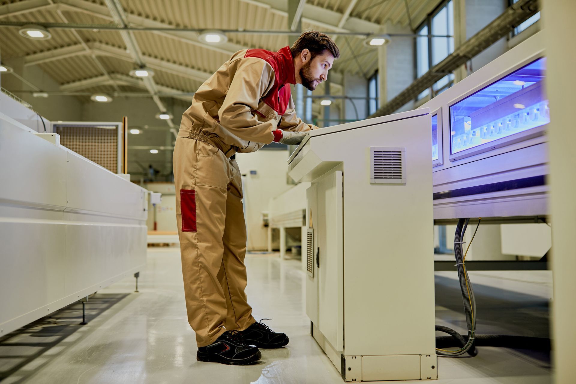 Man reaching into a microwave to retrieve an item, the oven door open. Time display shows 14:30.