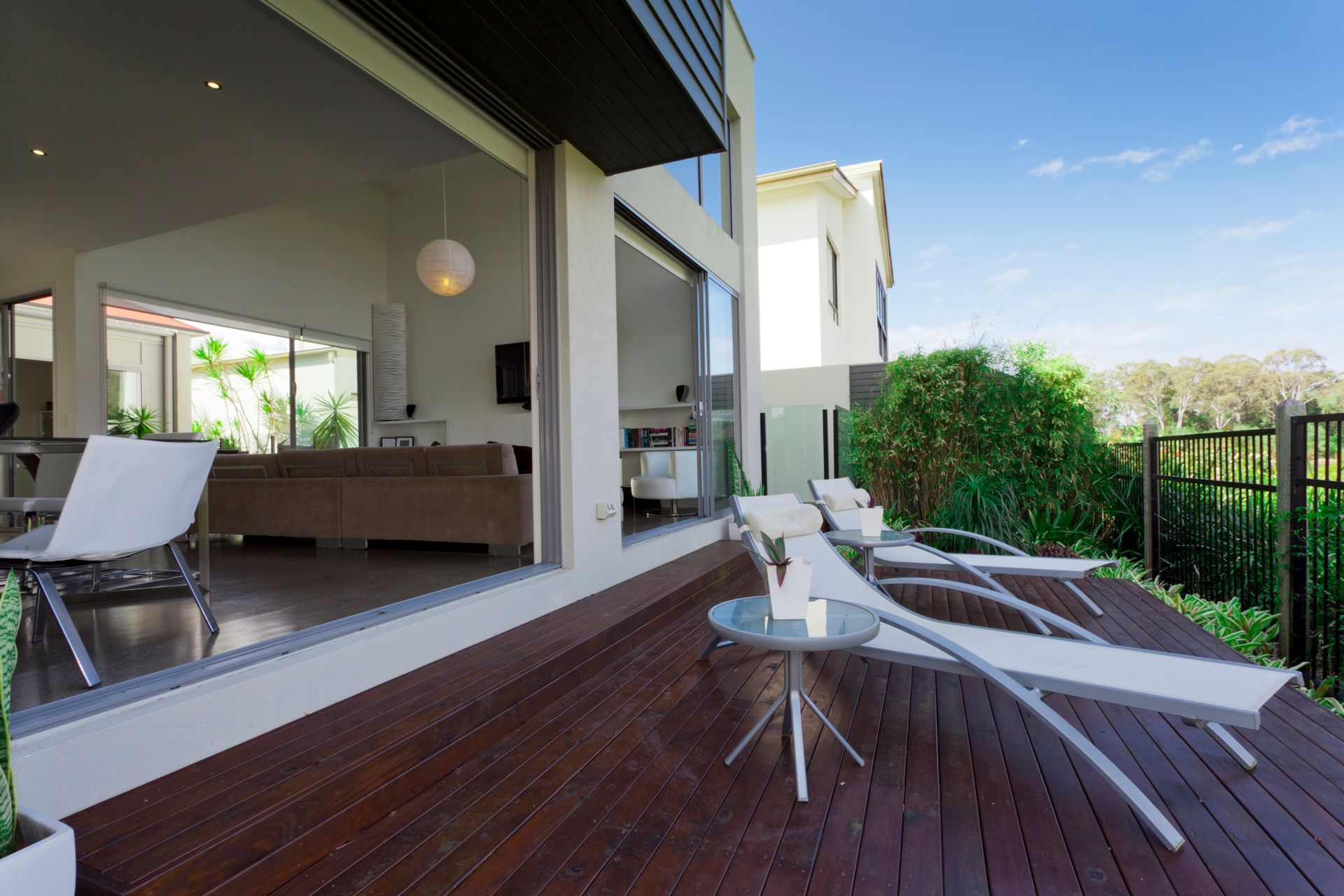 A deck with chairs and a table in front of a house