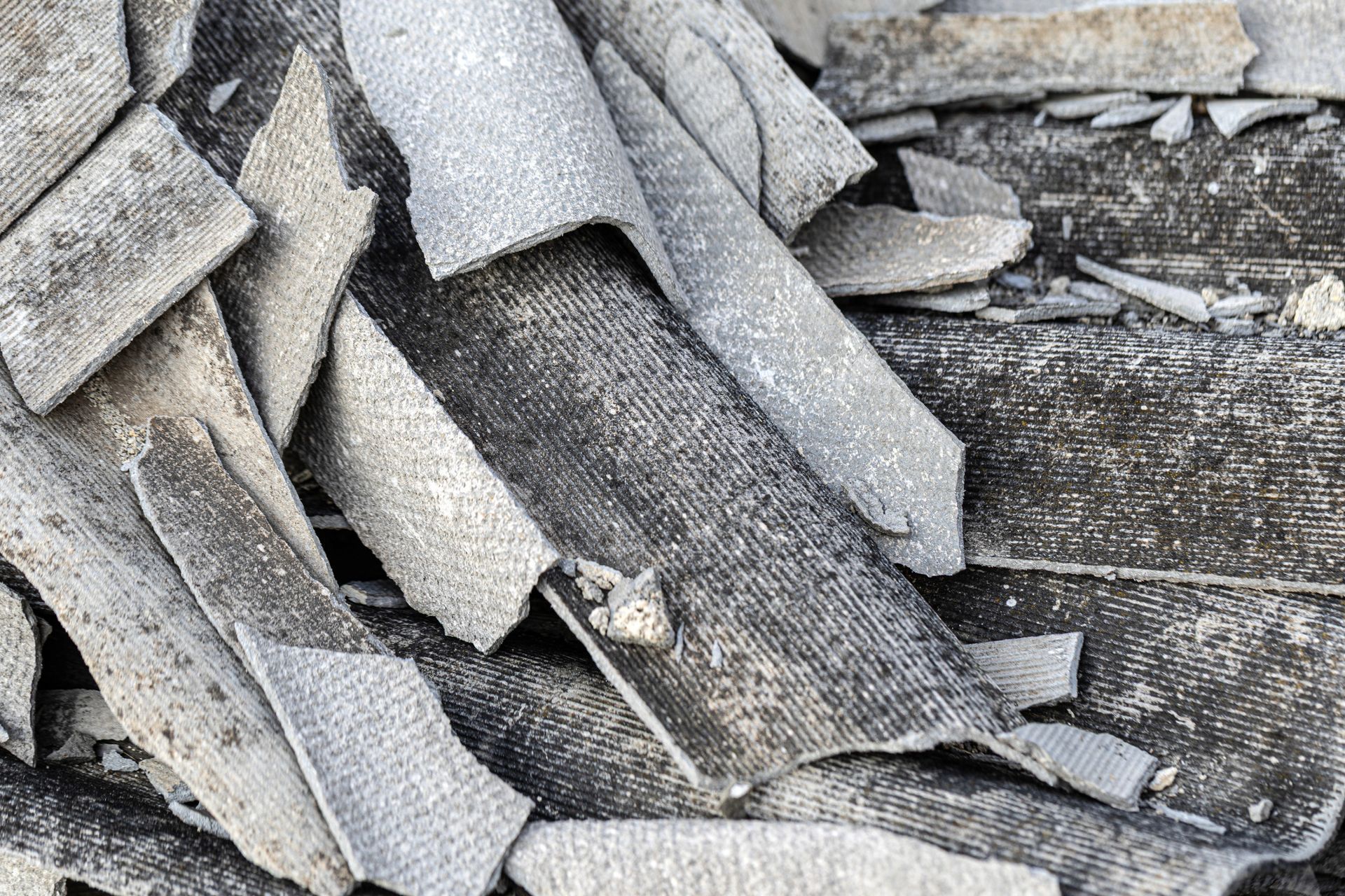 Scattered gray, broken asbestos roofing material.