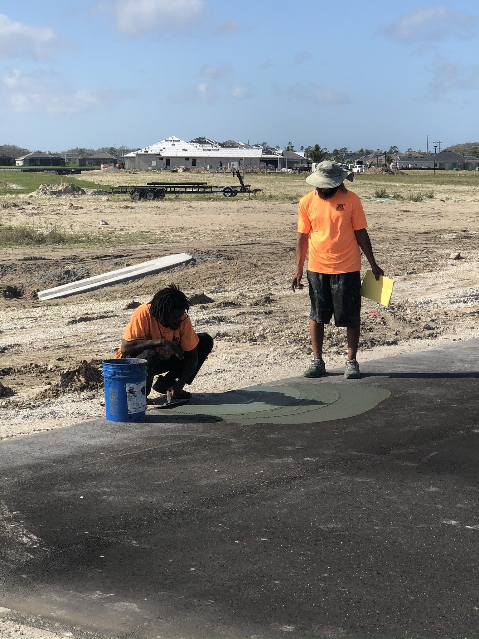 two construction workers are working on a road in a field.