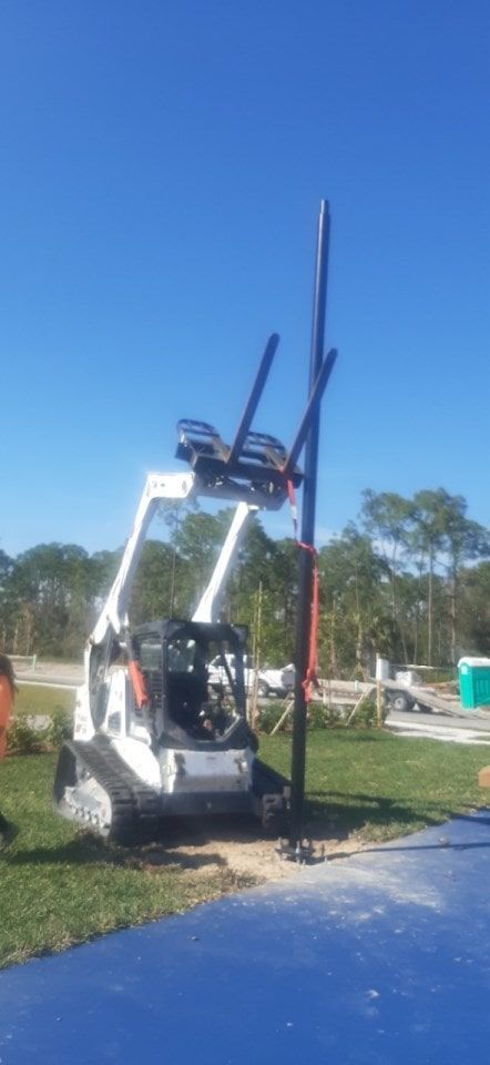 a bulldozer is lifting a chair on top of a pole .