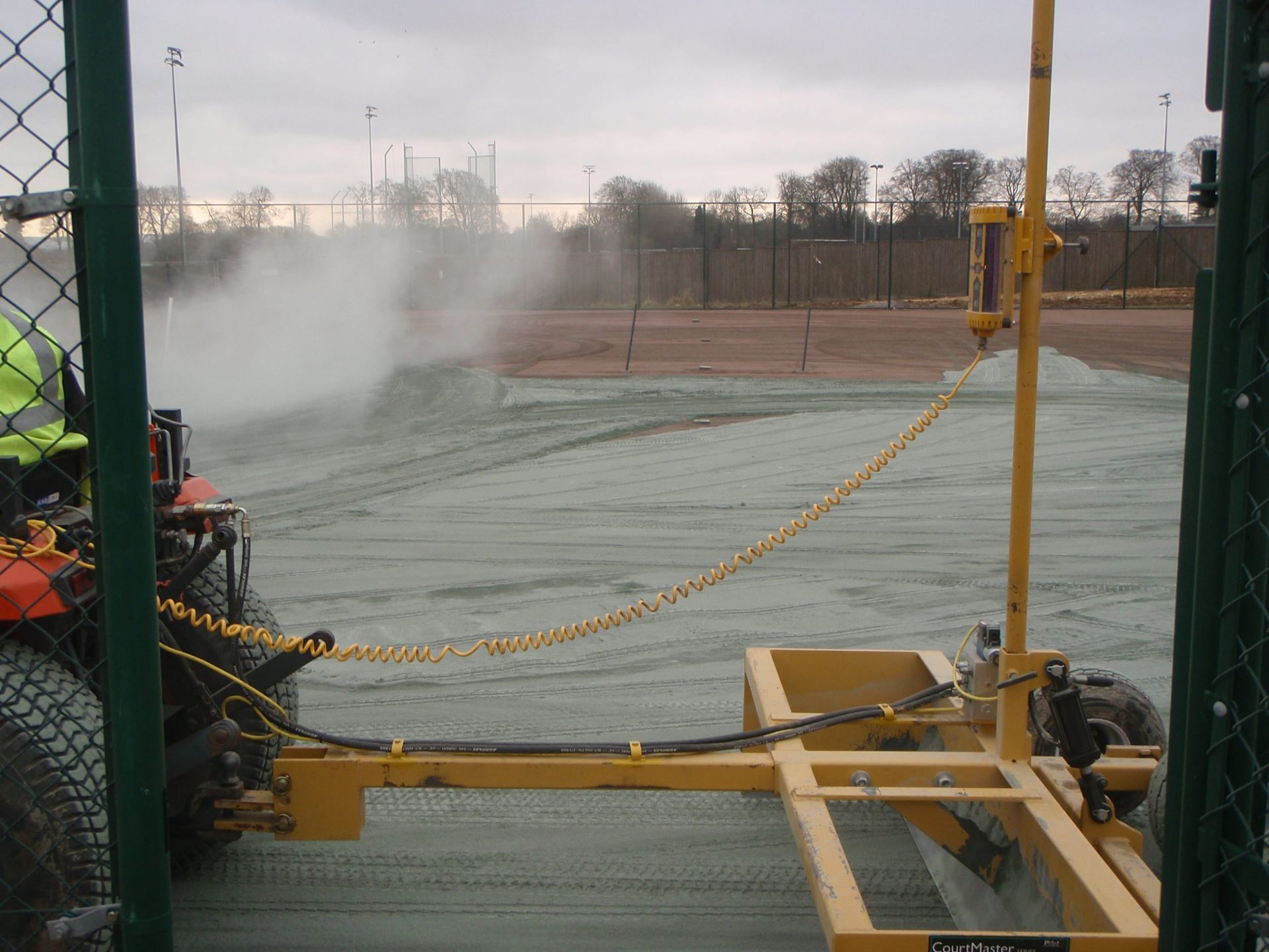 a tractor spraying a field with a yellow trailer attached to it