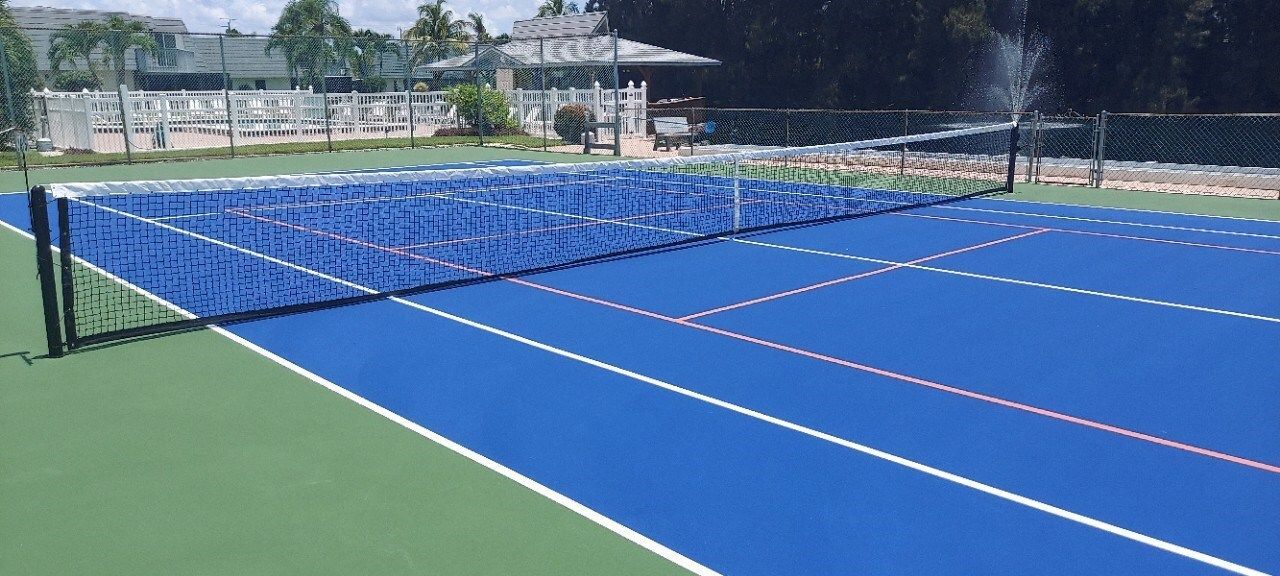 A tennis court with a blue net and a green court.