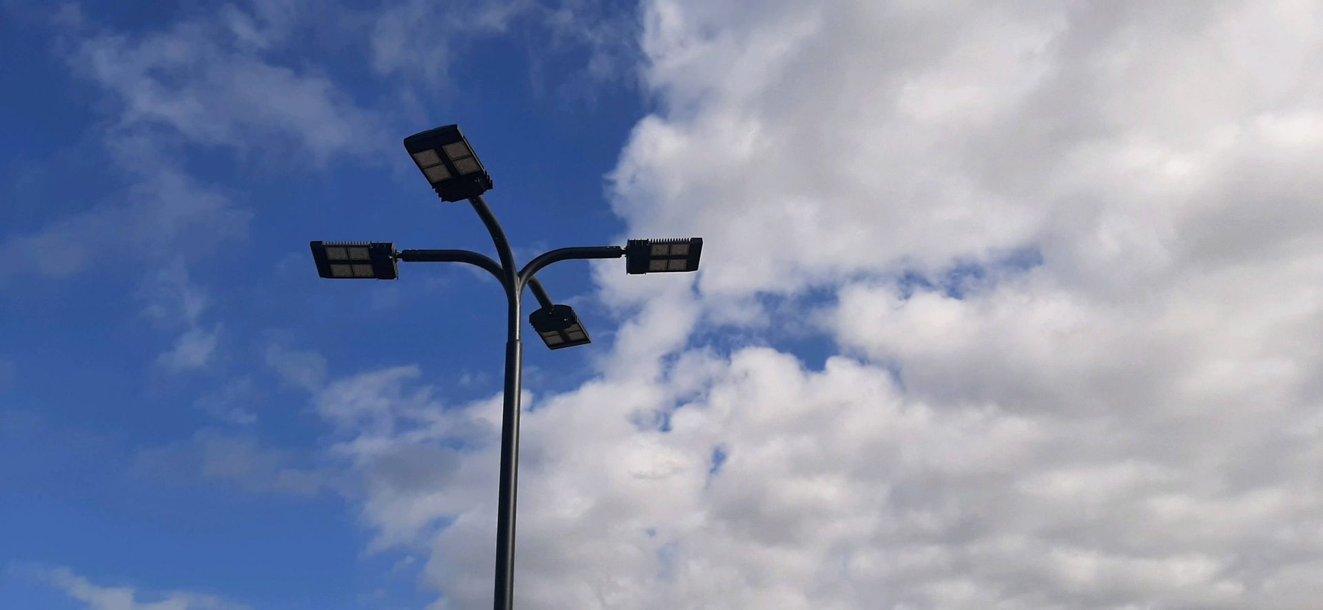 a street light is against a cloudy blue sky.