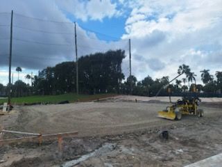 A yellow bulldozer is working on a dirt field.