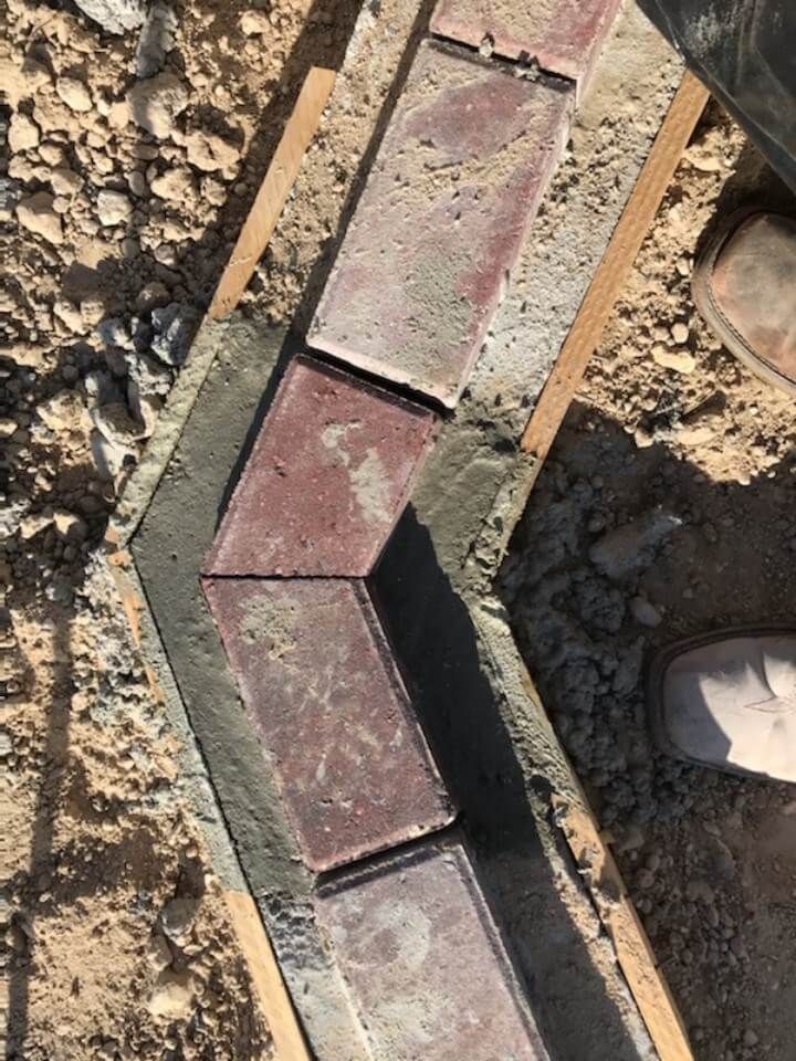 a person is standing next to a pile of bricks on the ground.