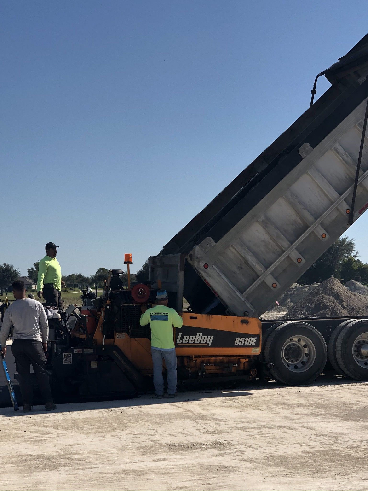 a large dump truck is being loaded with dirt on a construction site