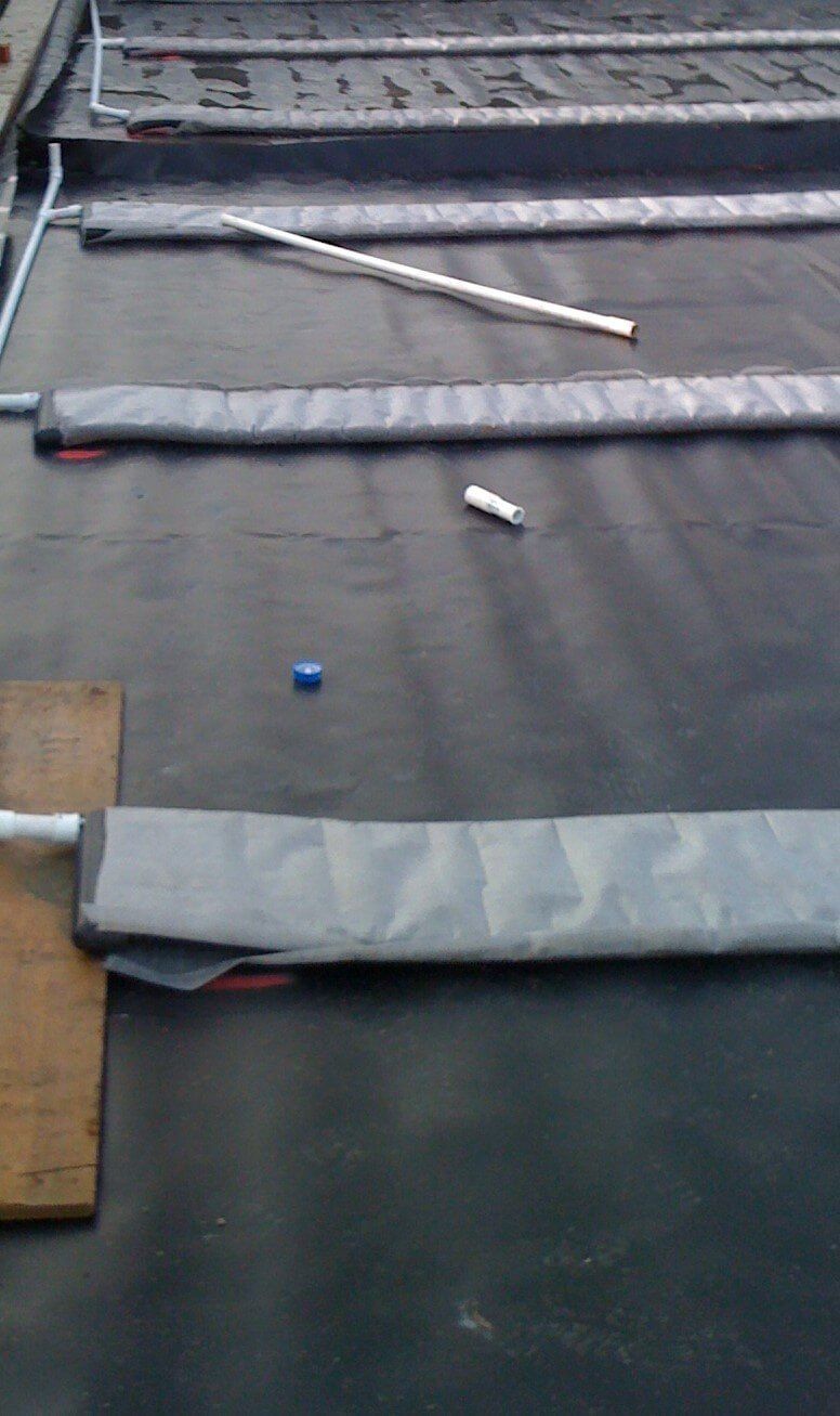 a piece of black fabric is laying on the ground next to a piece of wood .