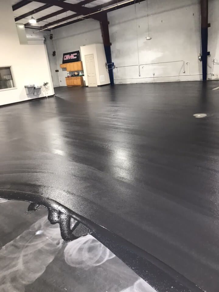 a large room with a black floor and a gmc sign on the wall .