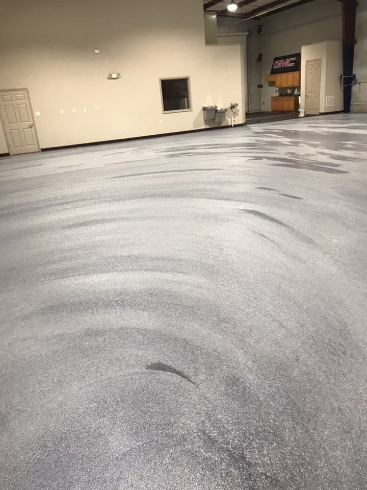 a large empty room with a gray floor and white walls