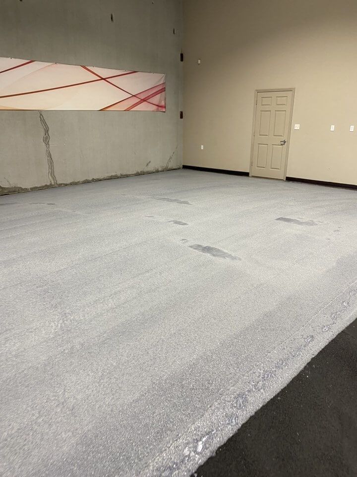 an empty room with a door and a painting on the wall