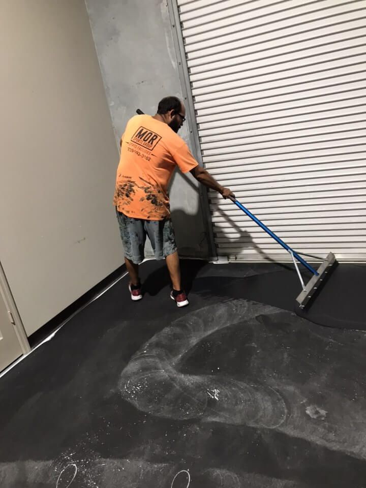 a man is cleaning the floor with a broom.