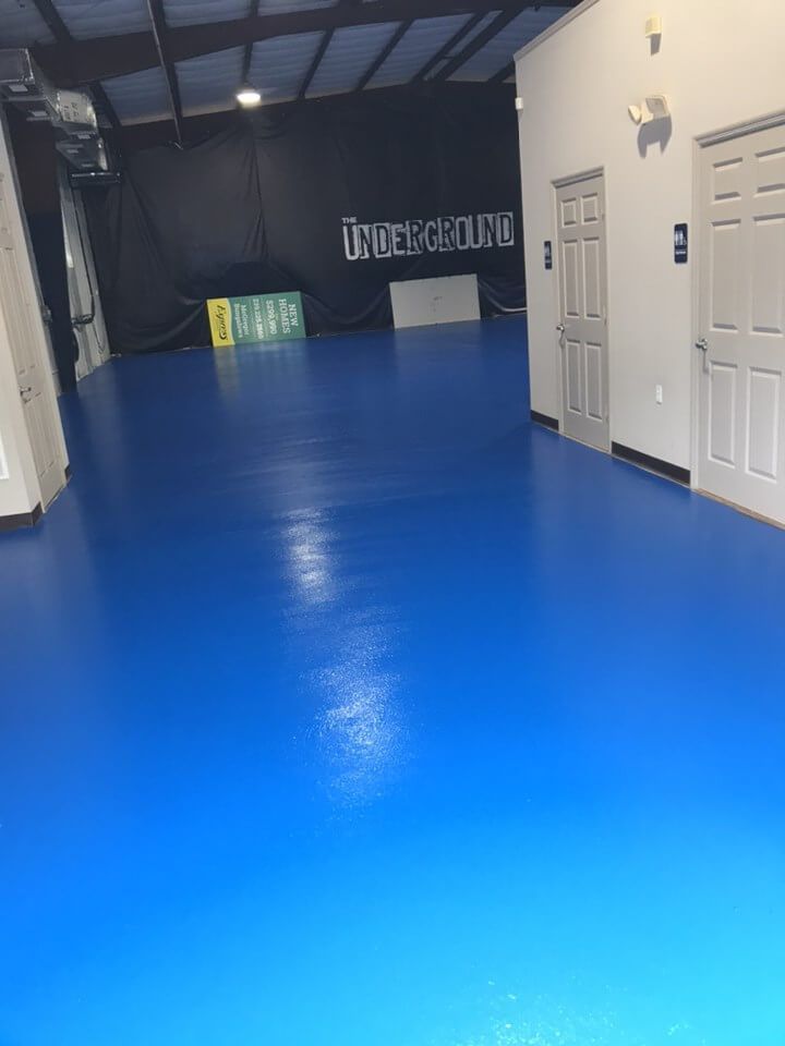 a large room with a blue floor and white walls.