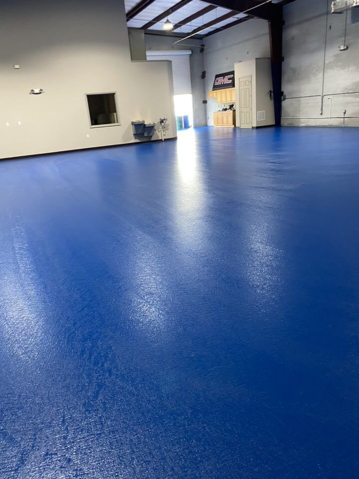 a large room with a blue floor and white walls